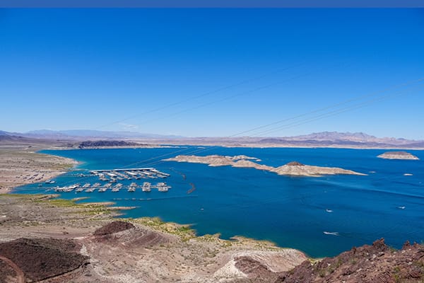 Lake, with boat docks, island in the middle and mountains in the background.