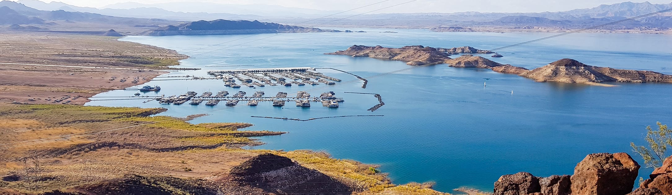 Lake with boat docks, island in the middle and beach on the left side.