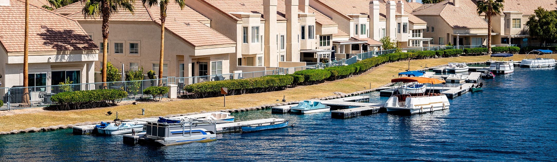 Lake with boat docks, boats and luxury houses.