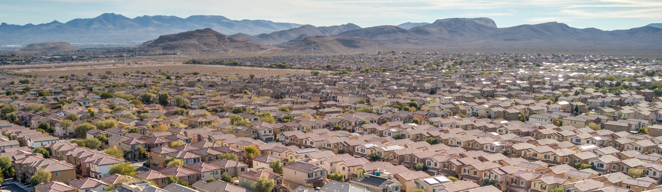 Aerial view of neighborhood with mountains in the background.