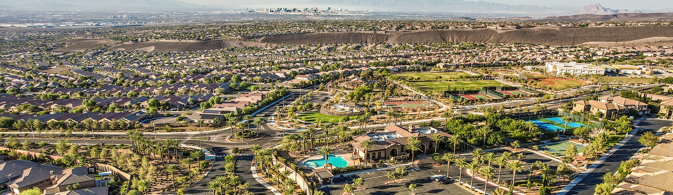 Aerial view of neighborhood with a street roundabout and 2 pools.