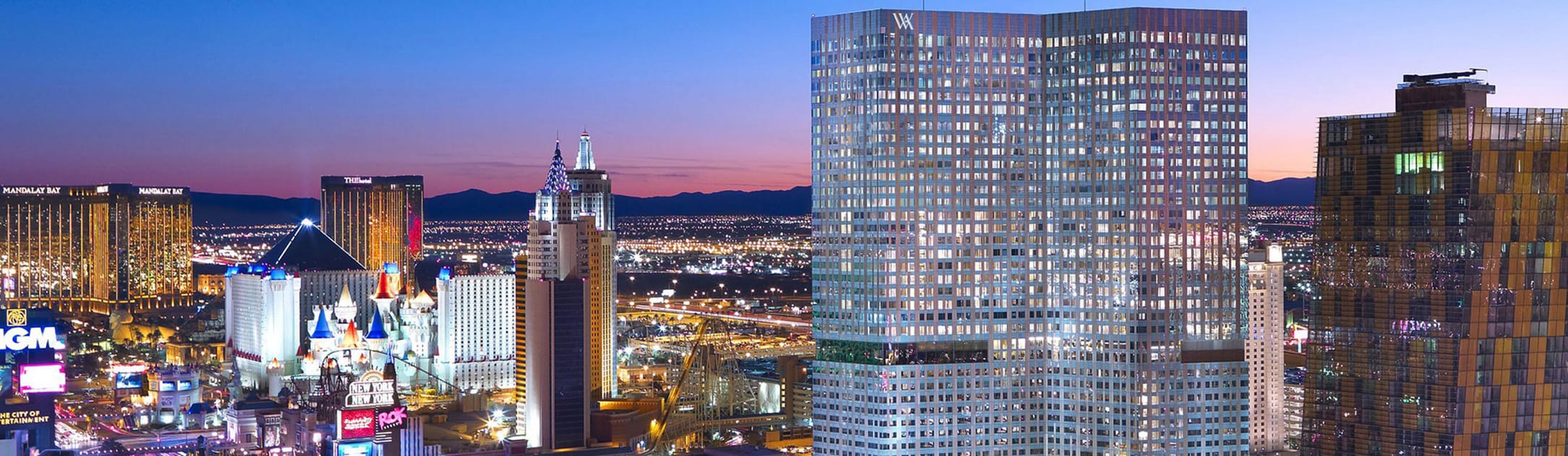 Night view of high rises, casinos, hotels with homes in the background.