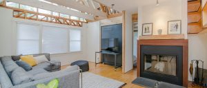 Living room with wood ceiling decor, fireplace and chalkboard.