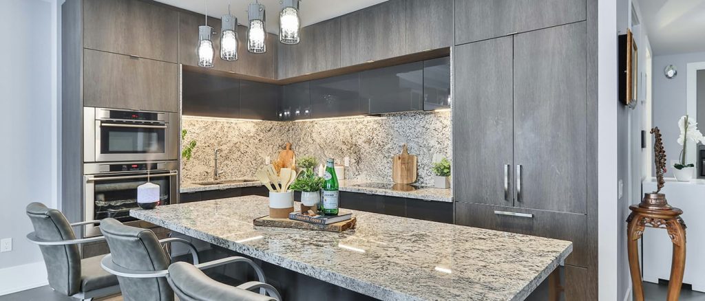 Modern gray kitchen with island and bar stools.